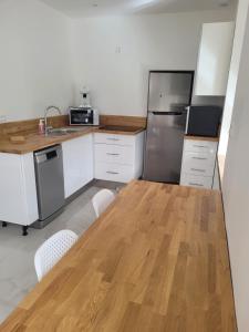 a kitchen with a wooden table and a refrigerator at Maison de Coton Ty Koton in Plourivo +13 photos