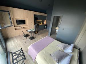 a bedroom with a bed and a table and a kitchen at Edificio Pantera - Soñar es crear in San Martín de los Andes