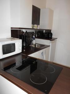 a small kitchen with a microwave and a sink at Anne's City Apartment in Jyväskylä