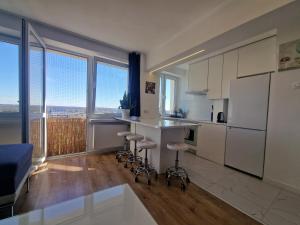 una cocina con nevera blanca y taburetes. en SKY Apartment przy Aqua Parku, en Częstochowa