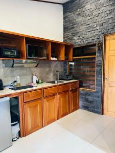 una cocina con armarios de madera y una pared de ladrillo en Apartamento Don Jarvey II, en Monteverde