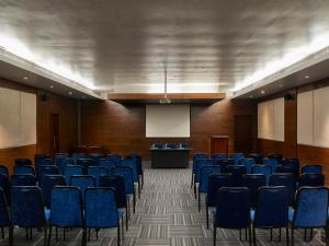 una sala de conferencias con sillas azules y un podio en Club Mahindra Madikeri, Coorg, en Madikeri 49 fotos más