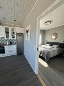 a large bedroom with a bed and a kitchen at Finnö Stugby in Geta