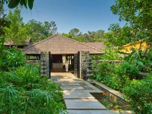 una pasarela que conduce a una casa en un jardín en Club Mahindra Madikeri, Coorg, en Madikeri