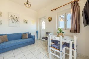 a living room with a blue couch and a table at kissamos seaside bliss in Kissamos