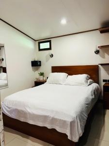 Un dormitorio con una cama grande con sábanas blancas. en Apartamento Don Jarvey II, en Monteverde 1 foto más