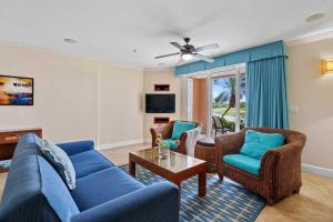 a living room with a blue couch and chairs at Golf Course View - Garden Studio condo - DR02 in Palm-Eagle Beach