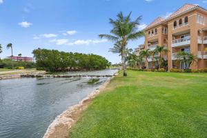 a river in front of a building with palm trees at Golf Course View - Garden Studio condo - DR02 in Palm-Eagle Beach