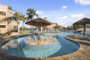a pool at a resort with chairs and umbrellas at Golf Course View - Garden Studio condo - DR02 in Palm-Eagle Beach