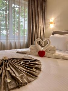 two swans making a heart on a bed at VLH Apartments in Constanţa
