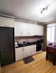a kitchen with white cabinets and a black refrigerator at Corfu Old Town Gregory in Corfu Town