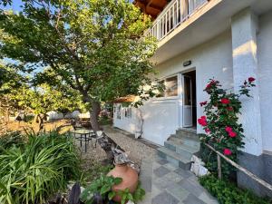 a house with a tree and a porch with flowers at Hectora -Private Sunrise Retreat in Kerveli