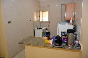 a kitchen with a counter top with a stove and a refrigerator at قريه اللوتس العلمين الساحل الشمالي in El Alamein
