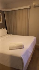 a white bed with a towel on top of it at 154apartamento lindo no itaim bibi in Sao Paulo