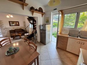 a kitchen and living room with a table and a refrigerator at Hectora -Private Sunrise Retreat in Kerveli