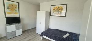 a room with a bed and a cabinet with a television at Monteurwohnung in Arzberg