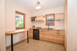 een keuken met houten kasten en een zwarte koelkast bij Domki u Wilka in Poronin