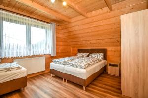 een slaapkamer met twee bedden in een blokhut bij Domki u Wilka in Poronin