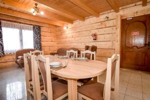een houten eetkamer met een tafel en stoelen bij Domki u Wilka in Poronin
