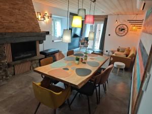 a dining room with a wooden table and chairs at Un Coin De Gîtes in Sciez