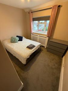 a small bedroom with a bed and a window at Spacious 3 bed house garden & parking sleeps 5 in Belvedere