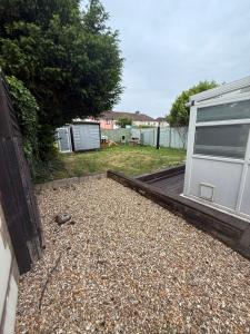 a backyard with a house and a gravel yard at Spacious 3 bed house garden & parking sleeps 5 in Belvedere