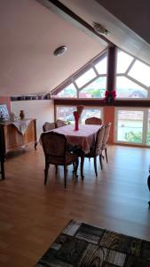 a dining room with a table and chairs and windows at Casa Emil in Floreşti