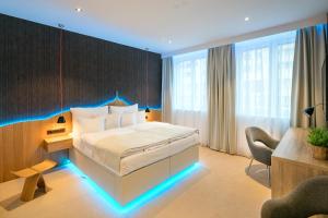 Habitación de hotel con cama con iluminación de color azul en Pytloun Grand Hotel Imperial, en Liberec