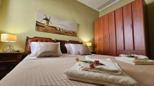 a bedroom with two beds with towels and a windmill at Lalovina Apartment in Herceg-Novi