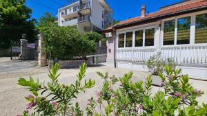 a building with a lot of flowers in front of it at Lalovina Apartment in Herceg-Novi