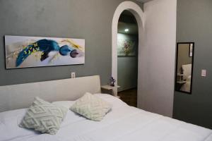 ein Schlafzimmer mit einem weißen Bett und zwei Kissen in der Unterkunft Cozy family apartment, kitchen in Mineral del Monte