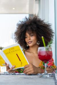 a woman sitting at a table reading a book at Hotel Zi One Luxury in Cartagena de Indias