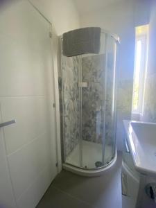 a shower with a glass door next to a sink at Porta Saracena Rooms in Agropoli