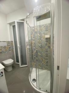 a bathroom with a shower and a toilet at Porta Saracena Rooms in Agropoli