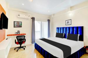 una camera da letto con un letto, una scrivania e una sedia di Collection O Mysore Central a Mysore