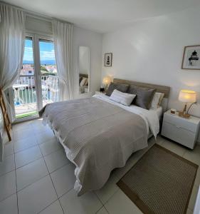 a bedroom with a large bed and a balcony at Marina & sea view apartment at Port Grec in Empuriabrava
