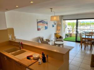 a kitchen with a sink and a living room at Marina & sea view apartment at Port Grec in Empuriabrava