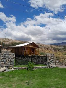 a house with a stone wall in front of it at Akon-Kahuac in Potrerillos +4 photos