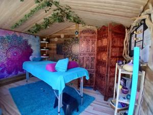a room with a blue bed in a house at L'O Ré des Bois Hébergement insolite Aube, Bain, Sauna, Kota, Massages in Laussonne