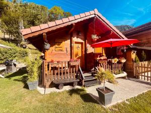 a small cabin with a red umbrella in a yard at LE BLANC NORDIQUE in Le Bouchet-Mont Charvin