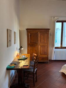 a dining room with a table and chairs and a cabinet at Affittacamere Medusa in Florence