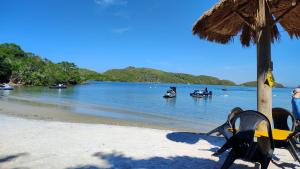 a group of people in boats on a beach at Chalé da Márcia com Piscina e Churrasqueira Privativos in Buzios