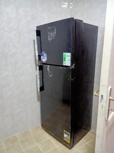 a black refrigerator in a corner of a room at كومباوند ستيلا بجوار مدينتي in Cairo