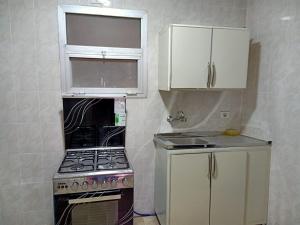 a small kitchen with a stove and a sink at كومباوند ستيلا بجوار مدينتي in Cairo