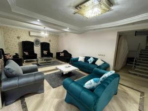 a living room with two blue couches and a table at كومباوند ستيلا بجوار مدينتي in Cairo