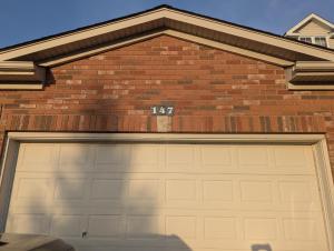 a garage door with the number on it at Basement two Queen beds and one single with two full washrooms by YKF airport in Kitchener