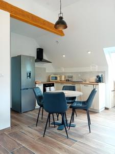 a kitchen with a table and chairs and a refrigerator at Appartement privatif à Trédarzec in Trédarzec