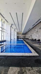 a large swimming pool with blue water in a building at Luxury Hotel apartment one bedroom - Aeon Towers for families or individuals in Sheikh Zayed