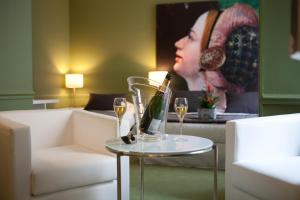 Hôtel Cecyl Reims Centre في رانس: طاولة مع كؤوس للنبيذ وصورة لامرأة