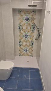 a bathroom with a toilet and a tile wall at Villa Margherita in Terrasini +50 photos